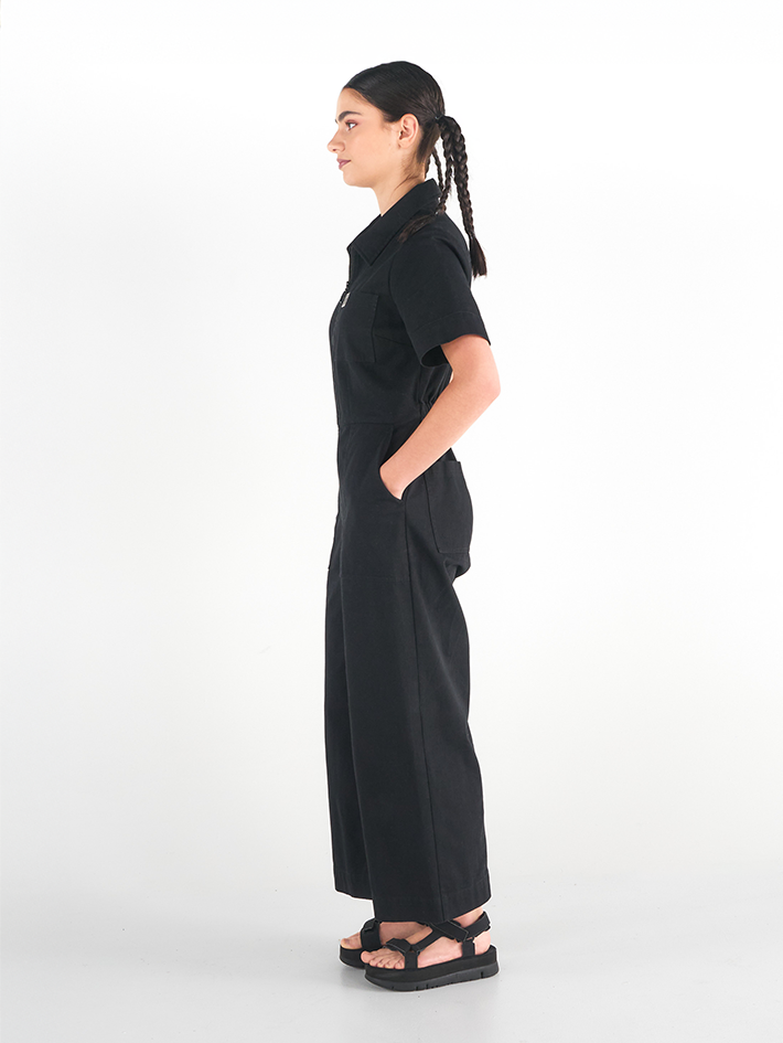 Side view of Stella Jumpsuit in Liquorice black cotton, relaxed workwear fit, Sydney design.